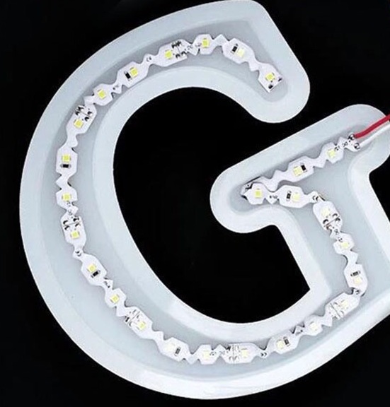 Installing S-shape LED strip for split neon sign making; flexible zigzag design fits custom channels perfectly before adding silicone tube.